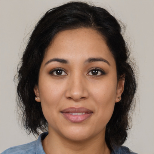 Joyful latino young-adult female with medium  brown hair and brown eyes