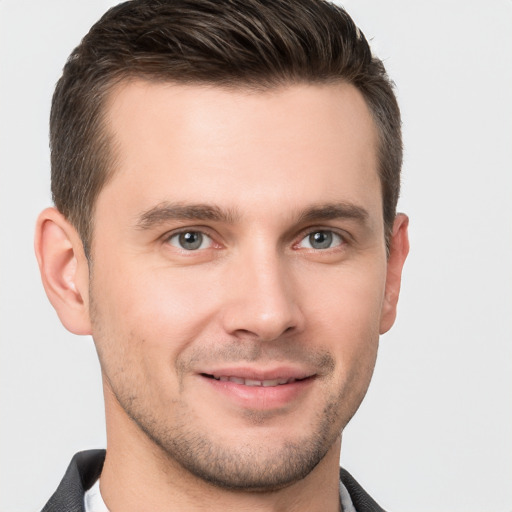 Joyful white young-adult male with short  brown hair and grey eyes