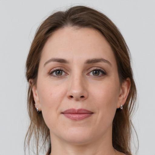 Joyful white young-adult female with medium  brown hair and grey eyes