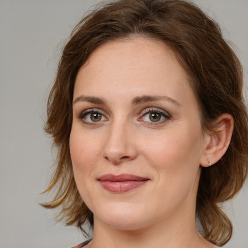 Joyful white young-adult female with medium  brown hair and green eyes