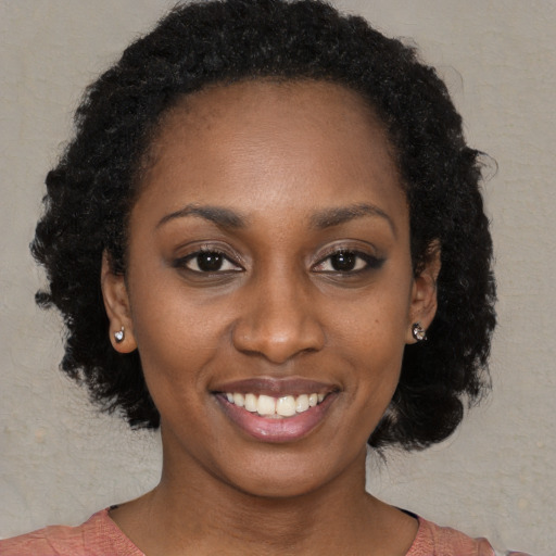 Joyful black young-adult female with medium  black hair and brown eyes
