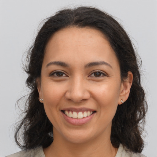 Joyful latino young-adult female with medium  brown hair and brown eyes