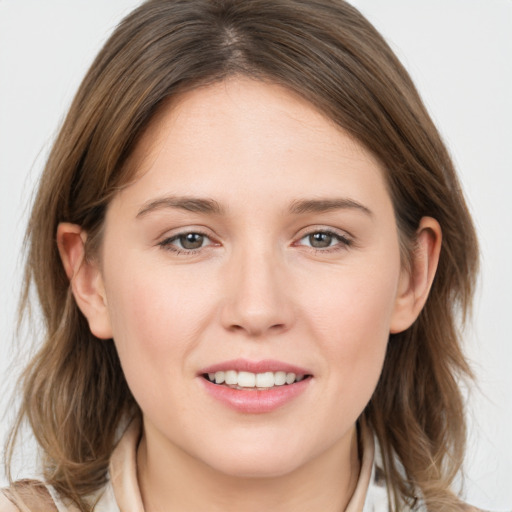 Joyful white young-adult female with medium  brown hair and grey eyes