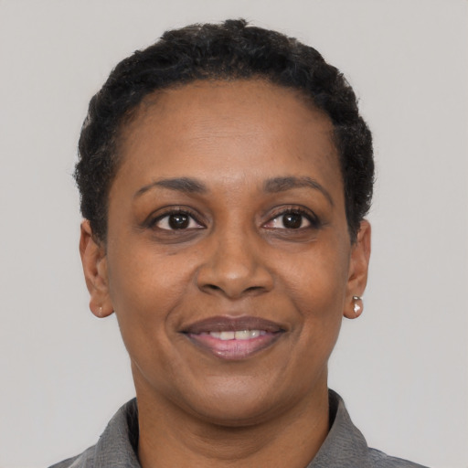 Joyful black adult female with short  black hair and brown eyes