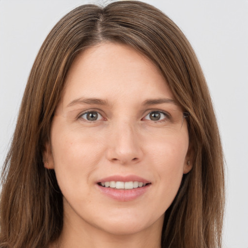 Joyful white young-adult female with long  brown hair and grey eyes