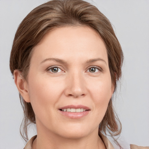 Joyful white young-adult female with medium  brown hair and grey eyes