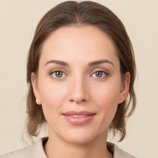 Joyful white young-adult female with medium  brown hair and grey eyes