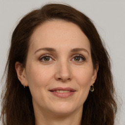 Joyful white adult female with long  brown hair and grey eyes