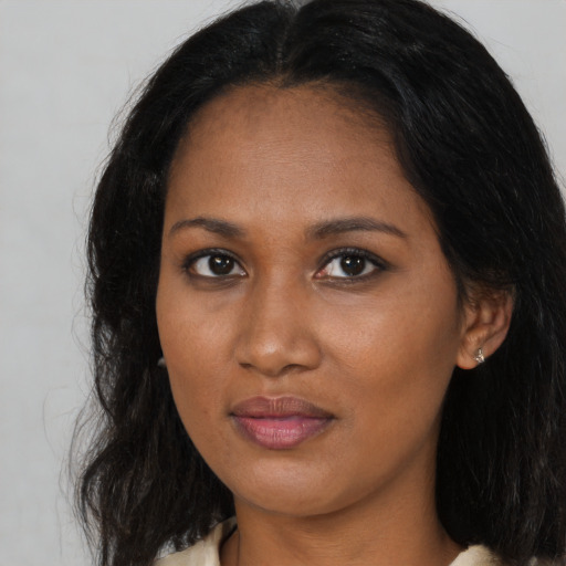 Joyful black young-adult female with long  brown hair and brown eyes