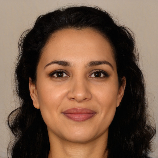 Joyful latino adult female with long  brown hair and brown eyes