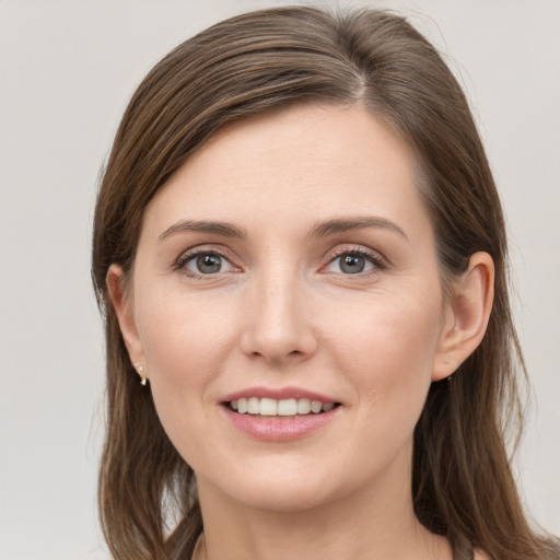 Joyful white young-adult female with long  brown hair and grey eyes