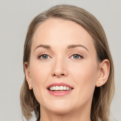 Joyful white young-adult female with medium  brown hair and grey eyes