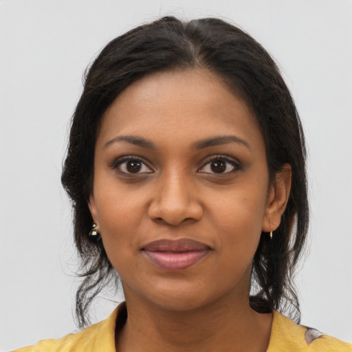 Joyful black young-adult female with long  brown hair and brown eyes