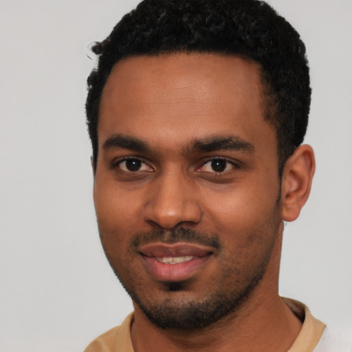 Joyful black young-adult male with short  black hair and brown eyes