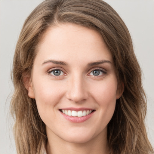 Joyful white young-adult female with long  brown hair and green eyes