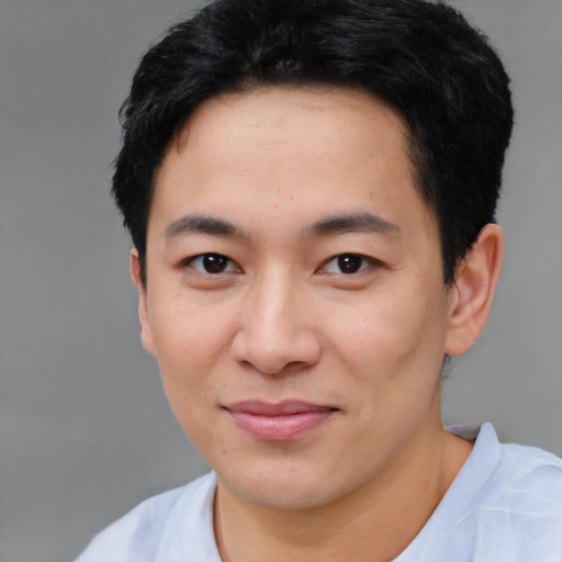 Joyful asian young-adult male with short  black hair and brown eyes