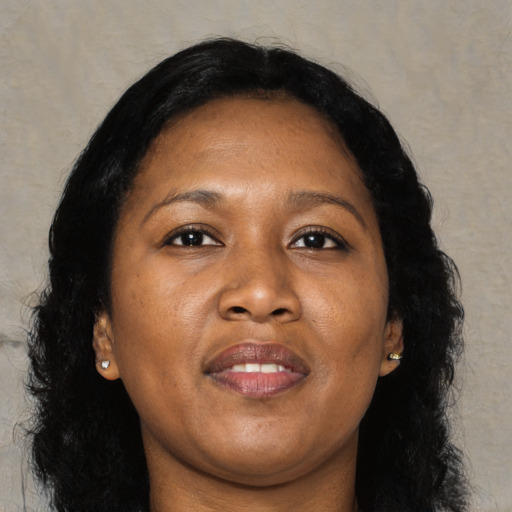 Joyful black adult female with long  brown hair and brown eyes