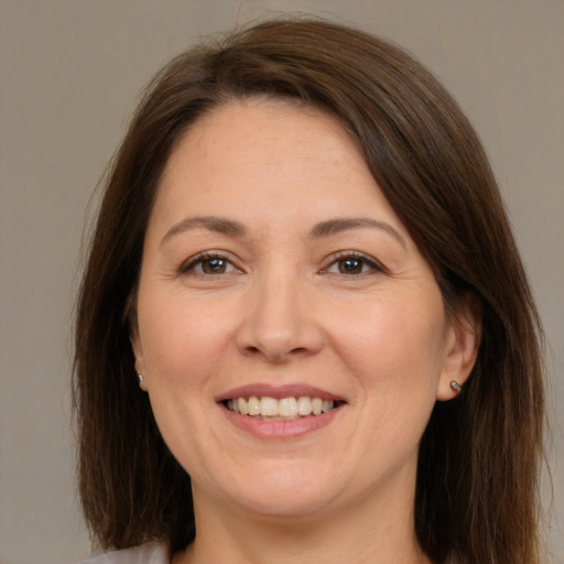 Joyful white adult female with medium  brown hair and brown eyes