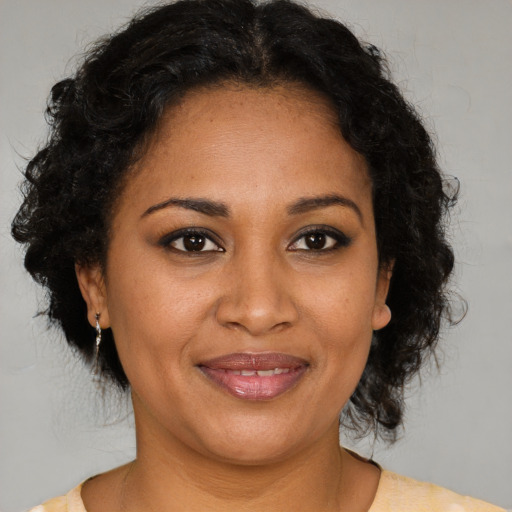 Joyful black adult female with medium  brown hair and brown eyes