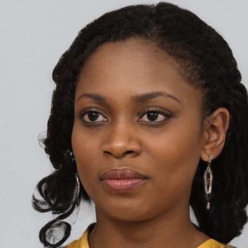 Joyful black young-adult female with long  black hair and brown eyes