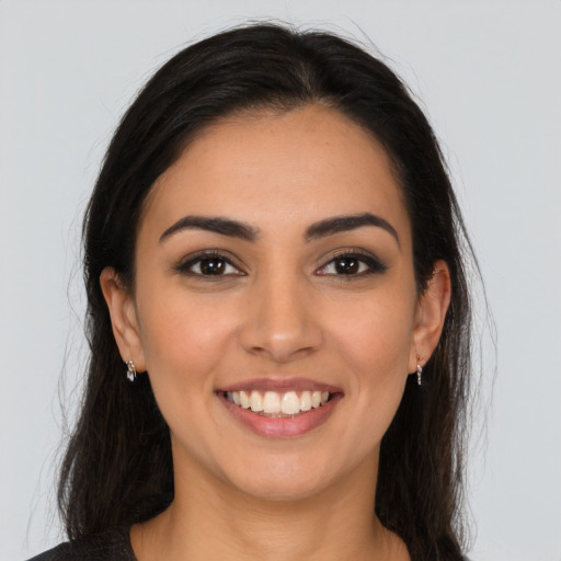 Joyful latino young-adult female with long  brown hair and brown eyes
