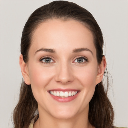 Joyful white young-adult female with medium  brown hair and grey eyes