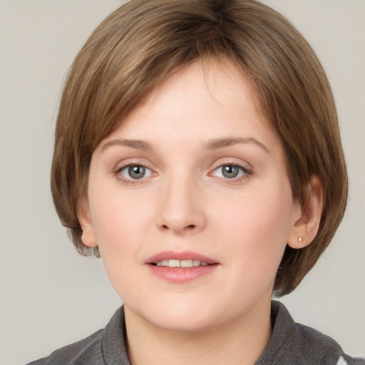 Joyful white young-adult female with medium  brown hair and grey eyes