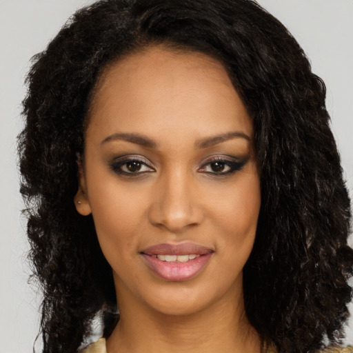 Joyful black young-adult female with long  black hair and brown eyes