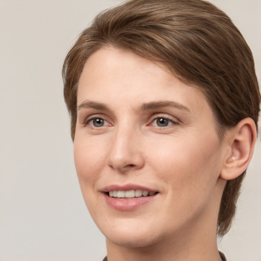 Joyful white young-adult female with short  brown hair and grey eyes