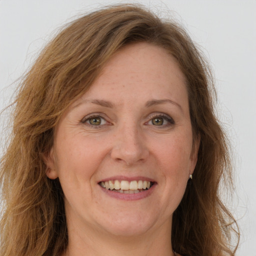 Joyful white adult female with long  brown hair and green eyes