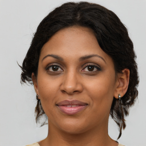 Joyful black young-adult female with medium  brown hair and brown eyes