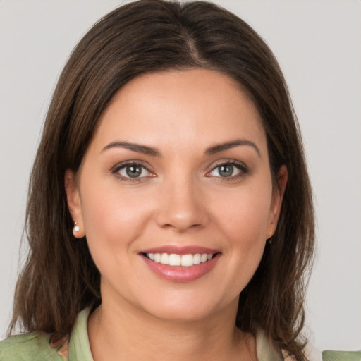 Joyful white young-adult female with medium  brown hair and green eyes