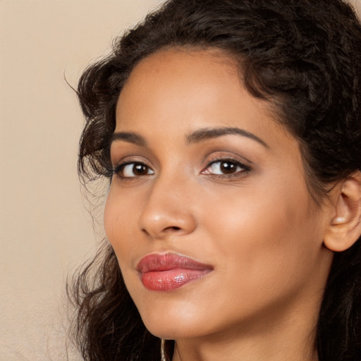 Joyful latino young-adult female with long  brown hair and brown eyes