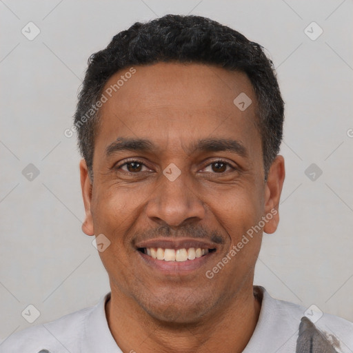 Joyful latino adult male with short  black hair and brown eyes