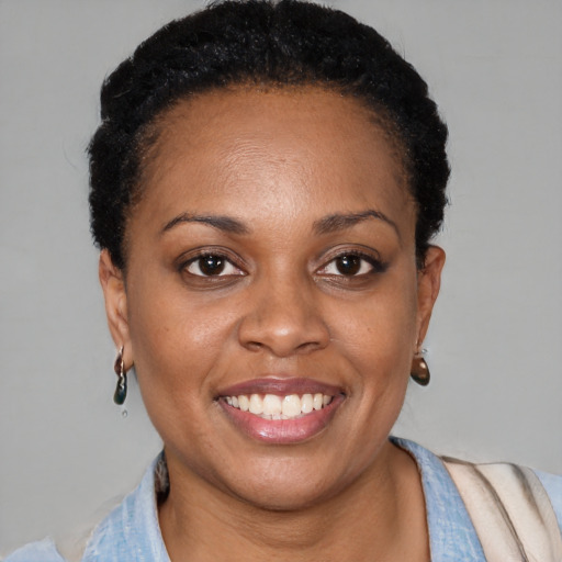 Joyful black young-adult female with short  black hair and brown eyes