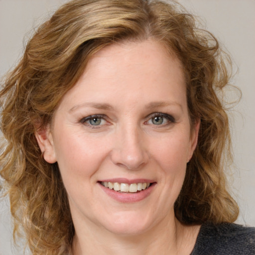 Joyful white young-adult female with medium  brown hair and blue eyes