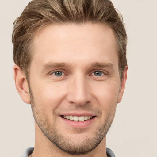 Joyful white young-adult male with short  brown hair and grey eyes