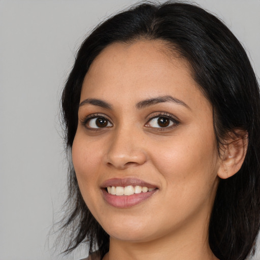 Joyful latino young-adult female with long  black hair and brown eyes