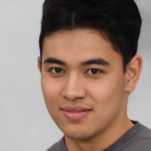 Joyful latino young-adult male with short  brown hair and brown eyes