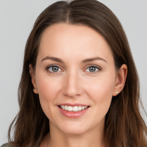 Joyful white young-adult female with long  brown hair and grey eyes