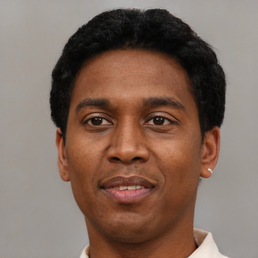 Joyful black adult male with short  black hair and brown eyes