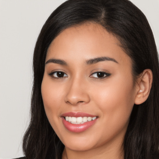 Joyful latino young-adult female with long  brown hair and brown eyes