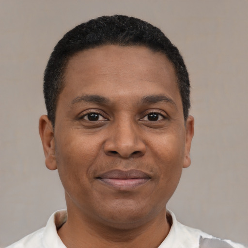 Joyful black young-adult male with short  black hair and brown eyes