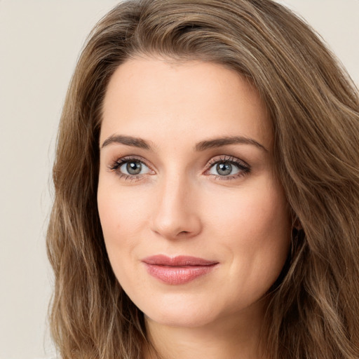 Joyful white young-adult female with long  brown hair and green eyes