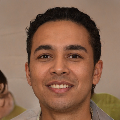 Joyful latino young-adult male with short  brown hair and brown eyes