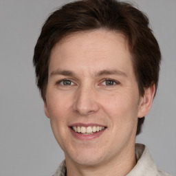 Joyful white adult male with short  brown hair and grey eyes