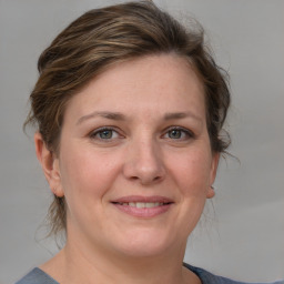 Joyful white adult female with medium  brown hair and grey eyes