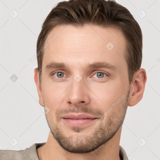 Joyful white young-adult male with short  brown hair and grey eyes