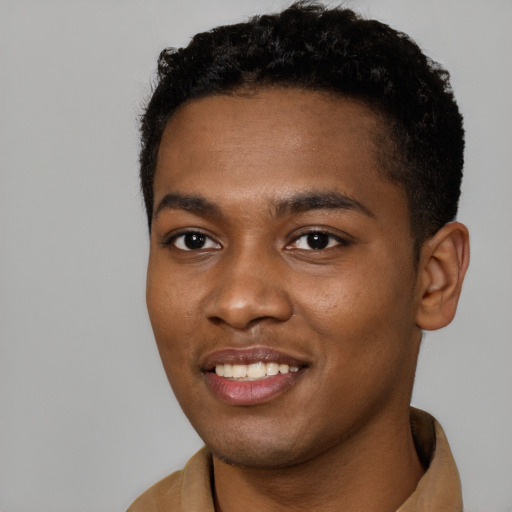 Joyful black young-adult male with short  black hair and brown eyes