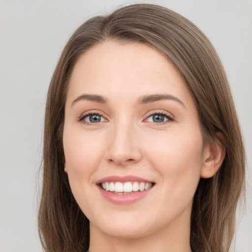 Joyful white young-adult female with long  brown hair and grey eyes